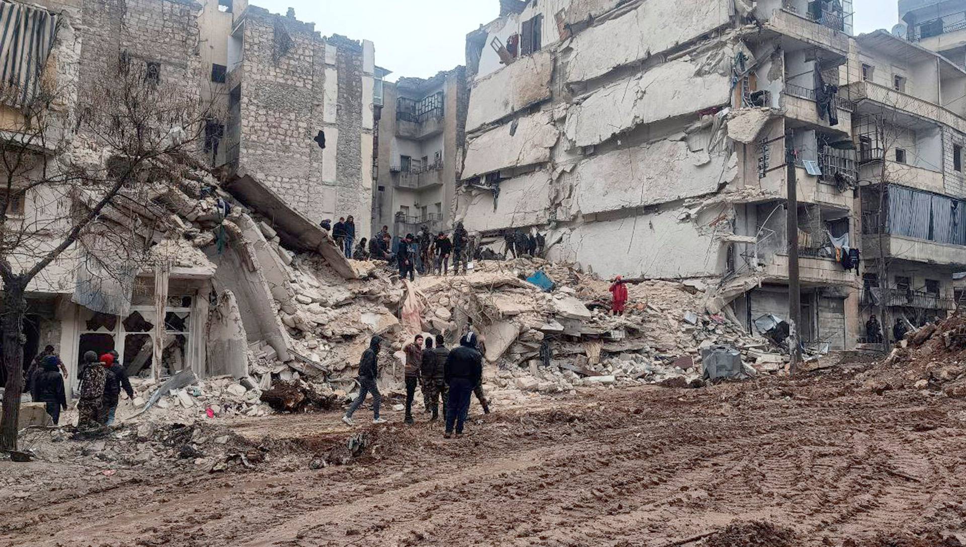 Rescuers search for survivors at the site of a collapsed building, following an earthquake in Aleppo