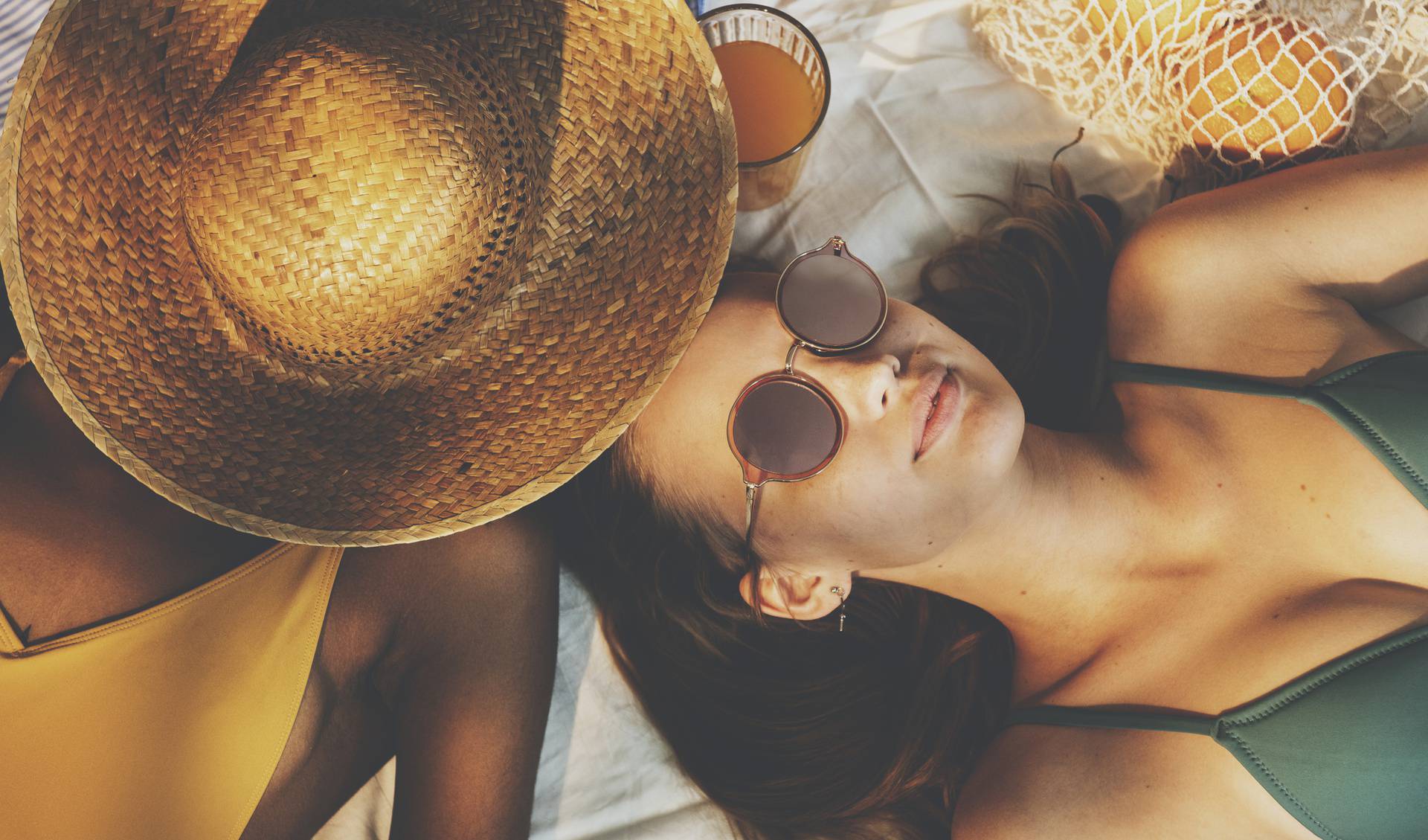 Cheerful girls in swimsuit sun tanning together