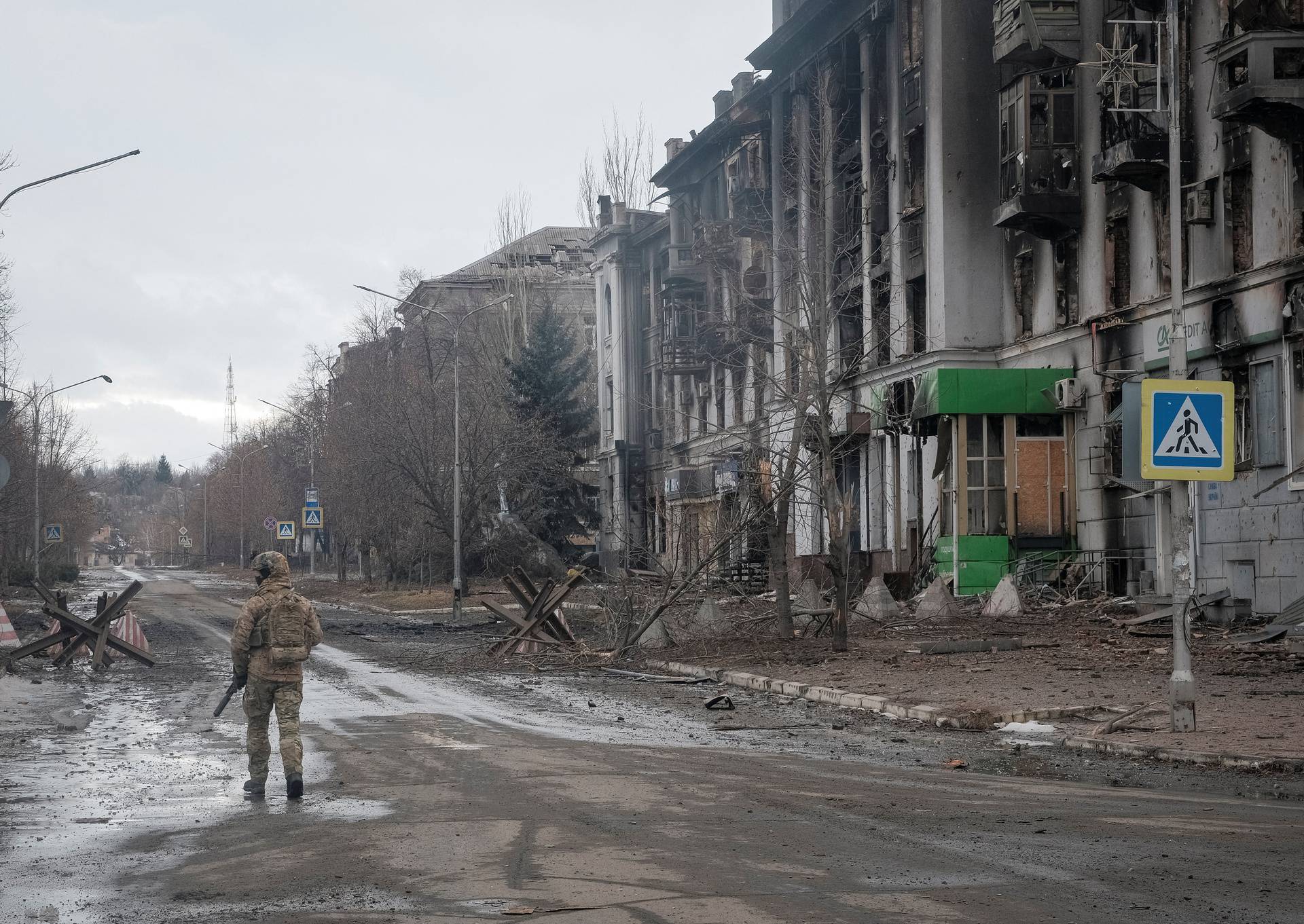 A Ukrainian serviceman walks an empty street as he patrols area in Bakhmut