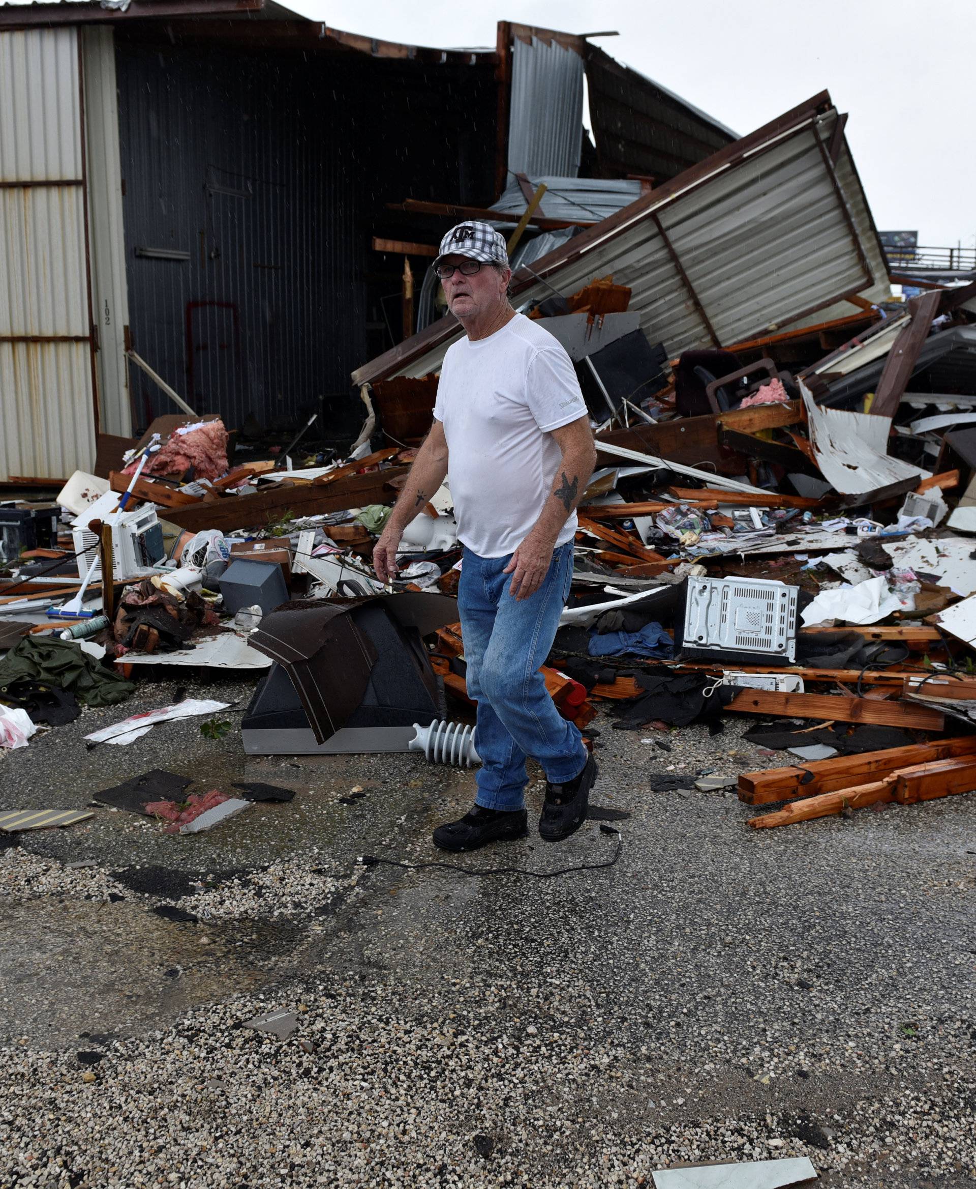 Billy Bryant looks through debris from a tornado that spun off of Hurricane Harvey after the storm made landfall on the Texas Gulf coast