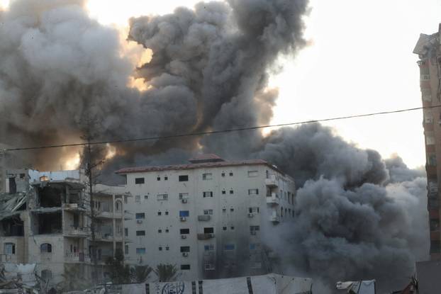 Smoke and flames rise as a residential building collapses after an Israeli air strike, in Gaza City
