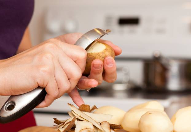 Color Image of Woman Peeling Potatoes in Her Kitchen