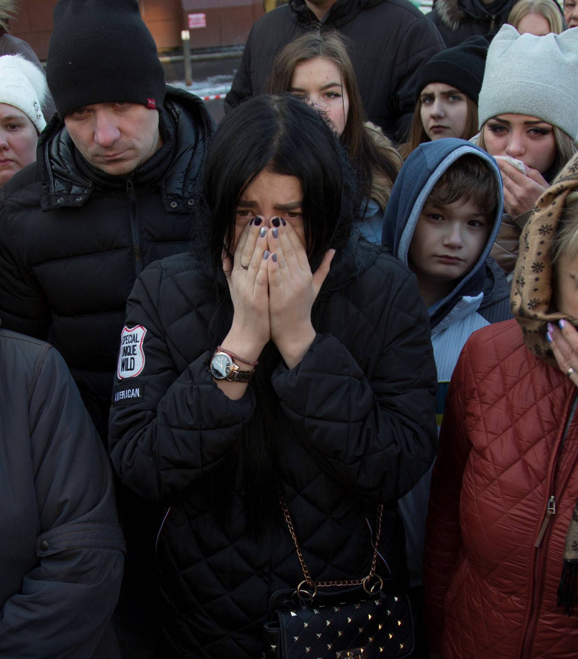 People mourn the victims of a shopping mall fire at a makeshift memorial in the Siberian city of Kemerovo