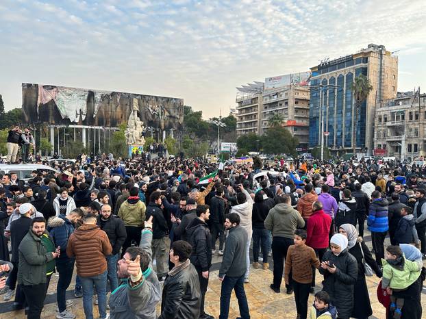 People gather at Saadallah al-Jabiri Square as they celebrate, in Aleppo