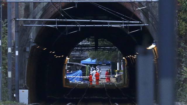 Members of the emergency services work next to a tram after it overturned killing 5 people and injuring 50 passengers in Croydon, south London