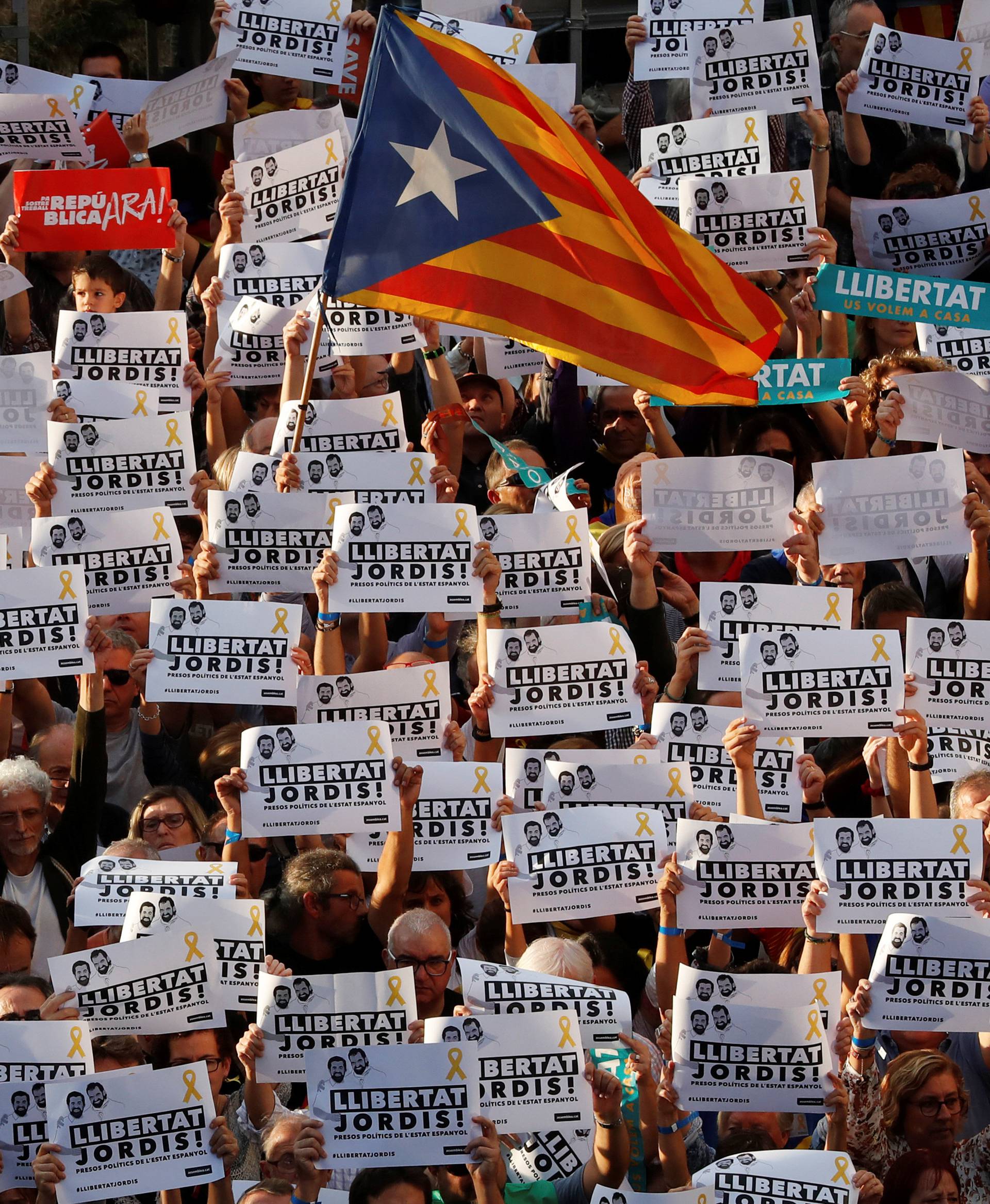 People hold up bannders during a demonstration organised by Catalan pro-independence movements ANC (Catalan National Assembly) and Omnium Cutural, following the imprisonment of their two leaders Jordi Sanchez and Jordi Cuixart, in Barcelona