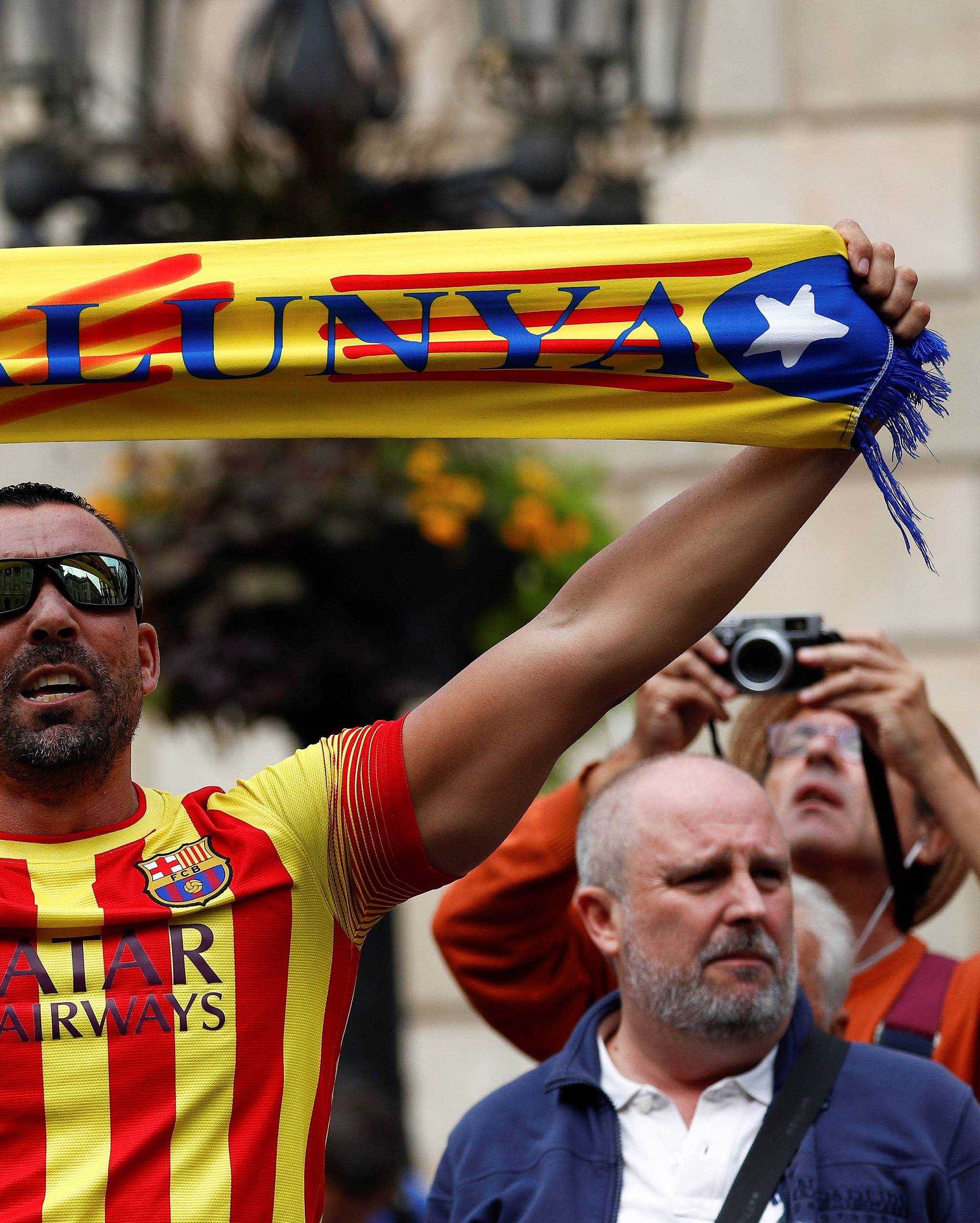 A man holds up a banner during a protest in Plaza Sant Jaume in Barcelona