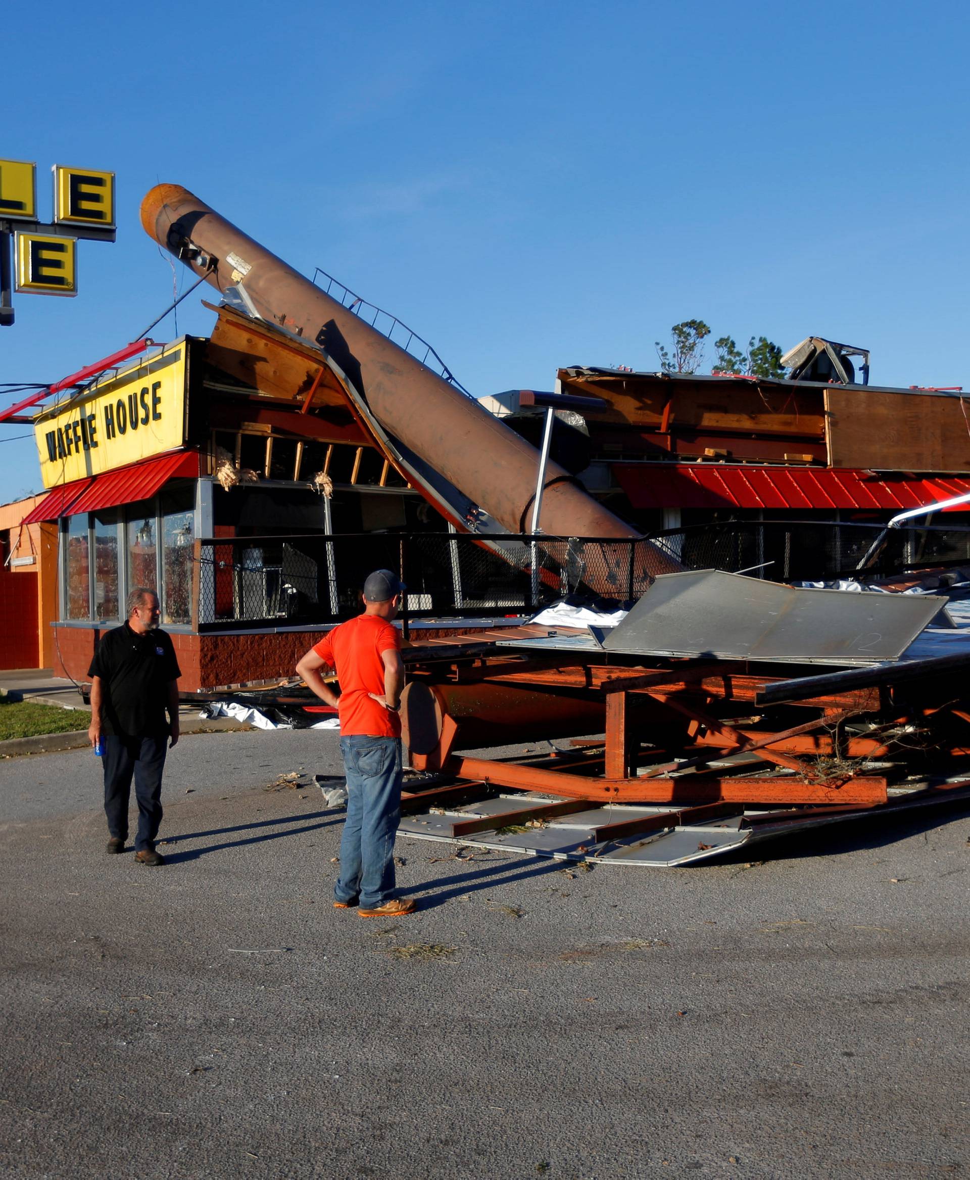 People inspect a Waffle House damaged by Hurricane Michael in Callaway,