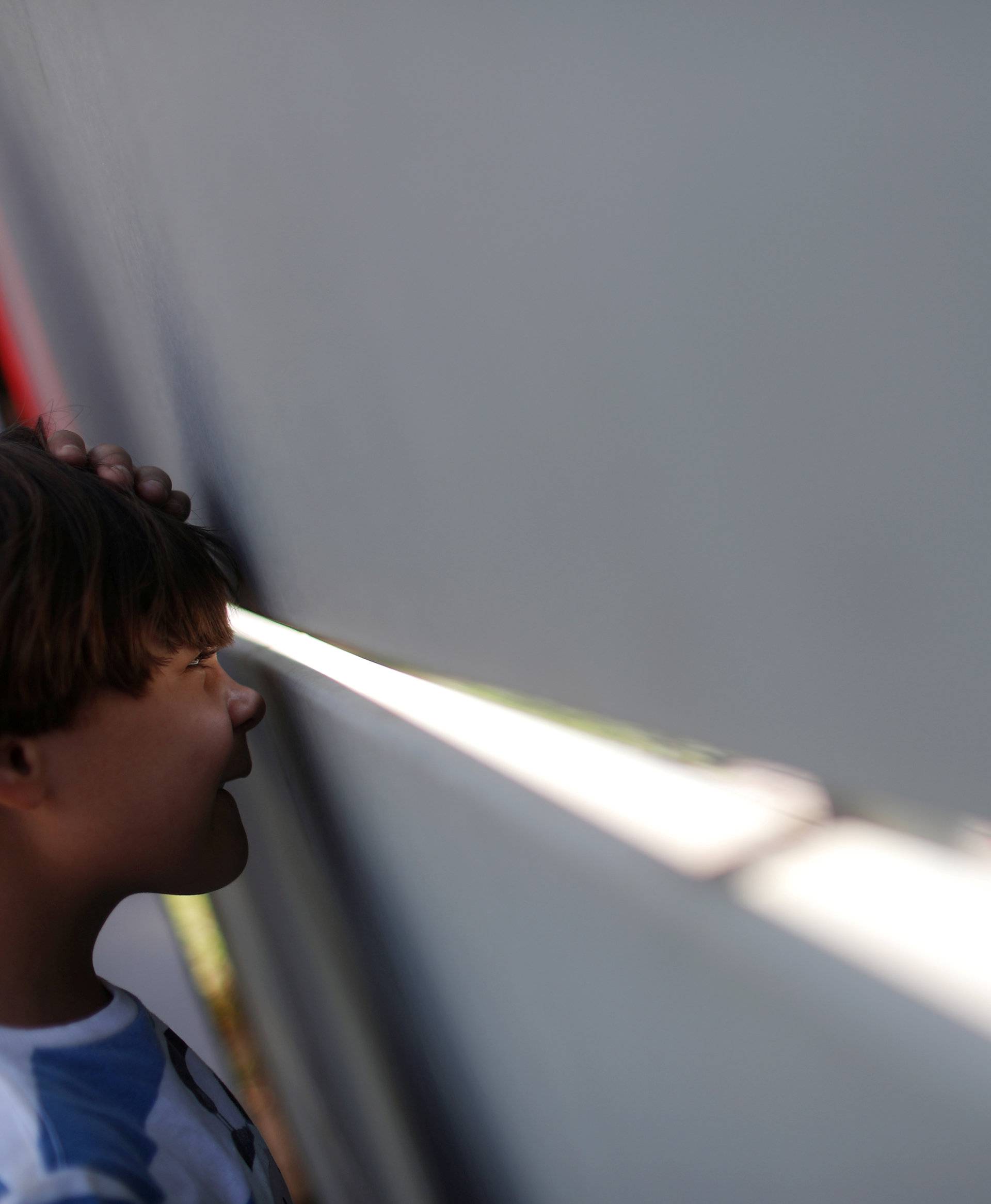 Child looks through the front door of Rio's soccer club Flamengo training center after a deadly fire in Rio de Janeiro