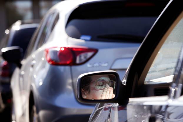 Hopkins wipes away tears during a "drive-in" church service at The Grove Church after large gatherings were banned due to the coronavirus outbreak in Marysville