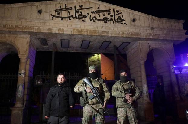 Syrian opposition fighters stand in front of University of Aleppo, after rebels opposed to President Bashar al-Assad said they had reached the heart of Aleppo