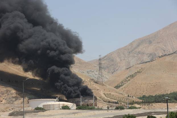 Smoke rises following what Iran says was an Israeli attack on Sharan Oil depot in Tehran
