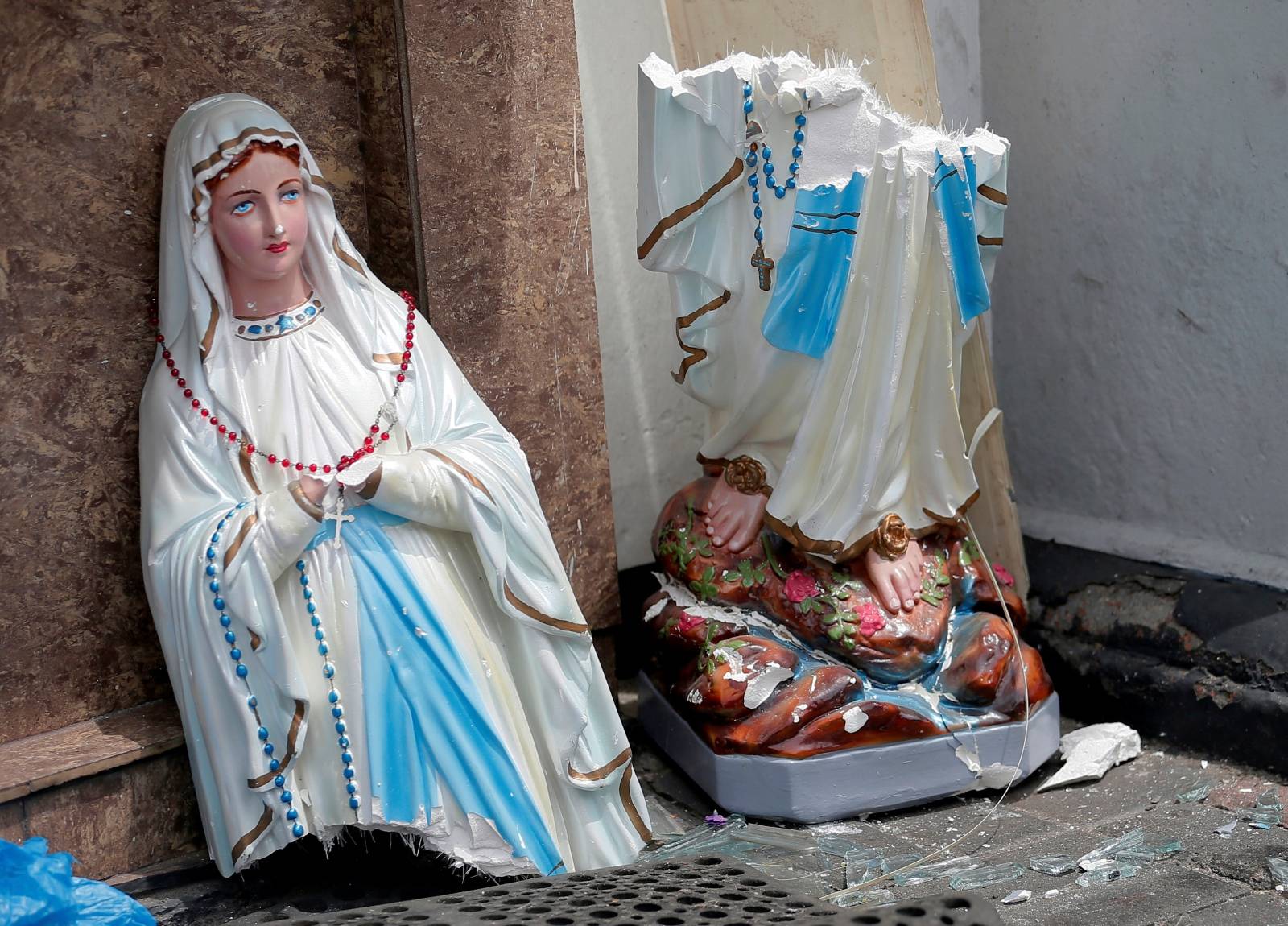 A statue of Virgin Marry broken in two parts is seen in front of the St. Anthony's Shrine, Kochchikade church after an explosion in Colombo