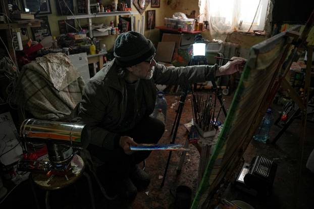 Ukrainian artist works at his studio during a power blackout in Kyiv
