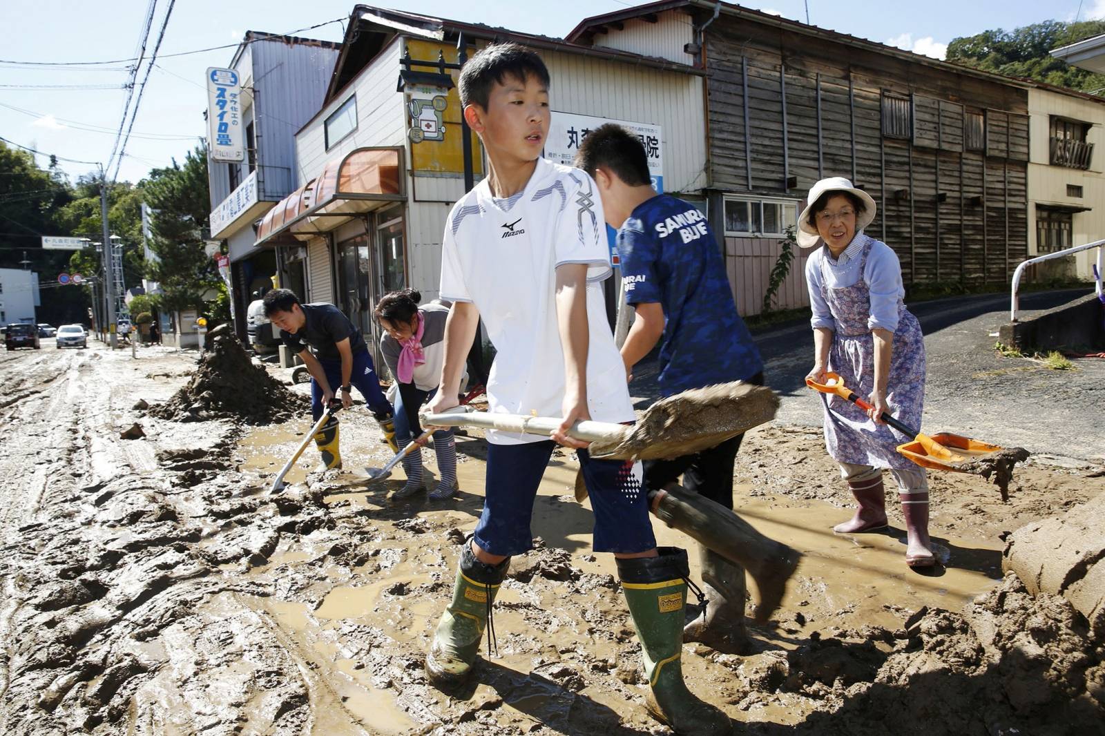 Schoolchildren and residents remove mud after flooding caused by Typhoon Hagibis in Marumori