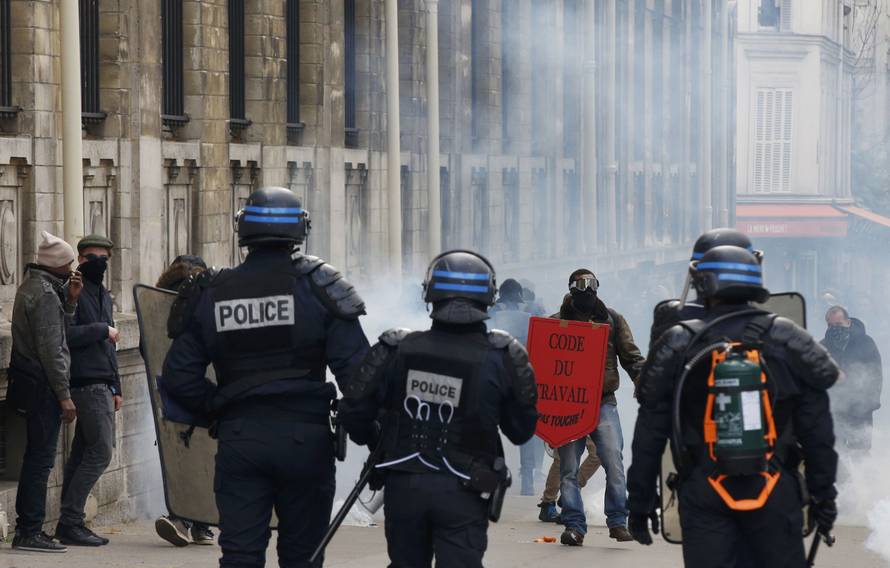 Masked youths face off with French riot police attend a demonstration against the French labour law proposal in Paris