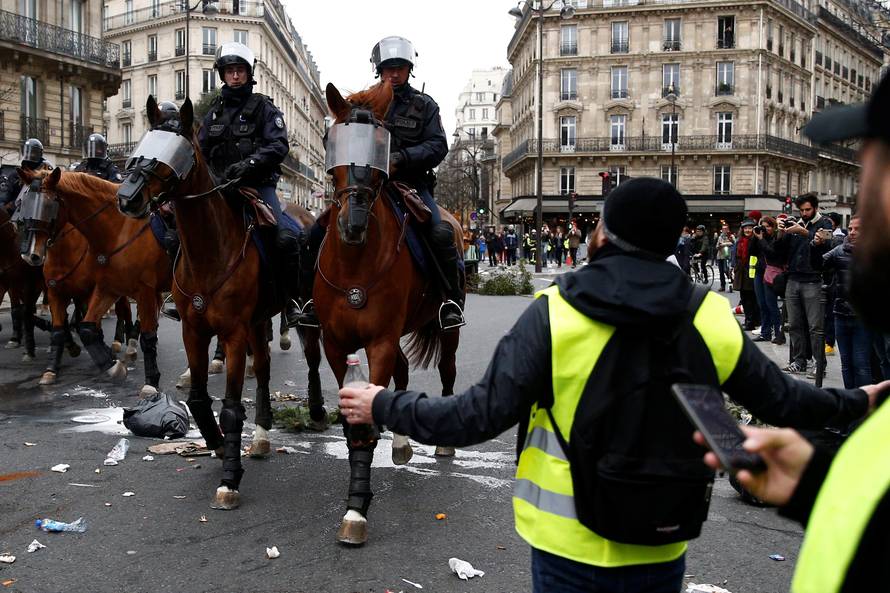 French mounted police advance during clashes with protesters wearing yellow vests at a demonstration during a national day of protest by the "yellow vests" movement in Paris