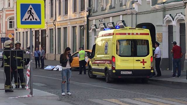 An ambulance is parked near a damaged taxi, which ran into crowds of people in central Moscow