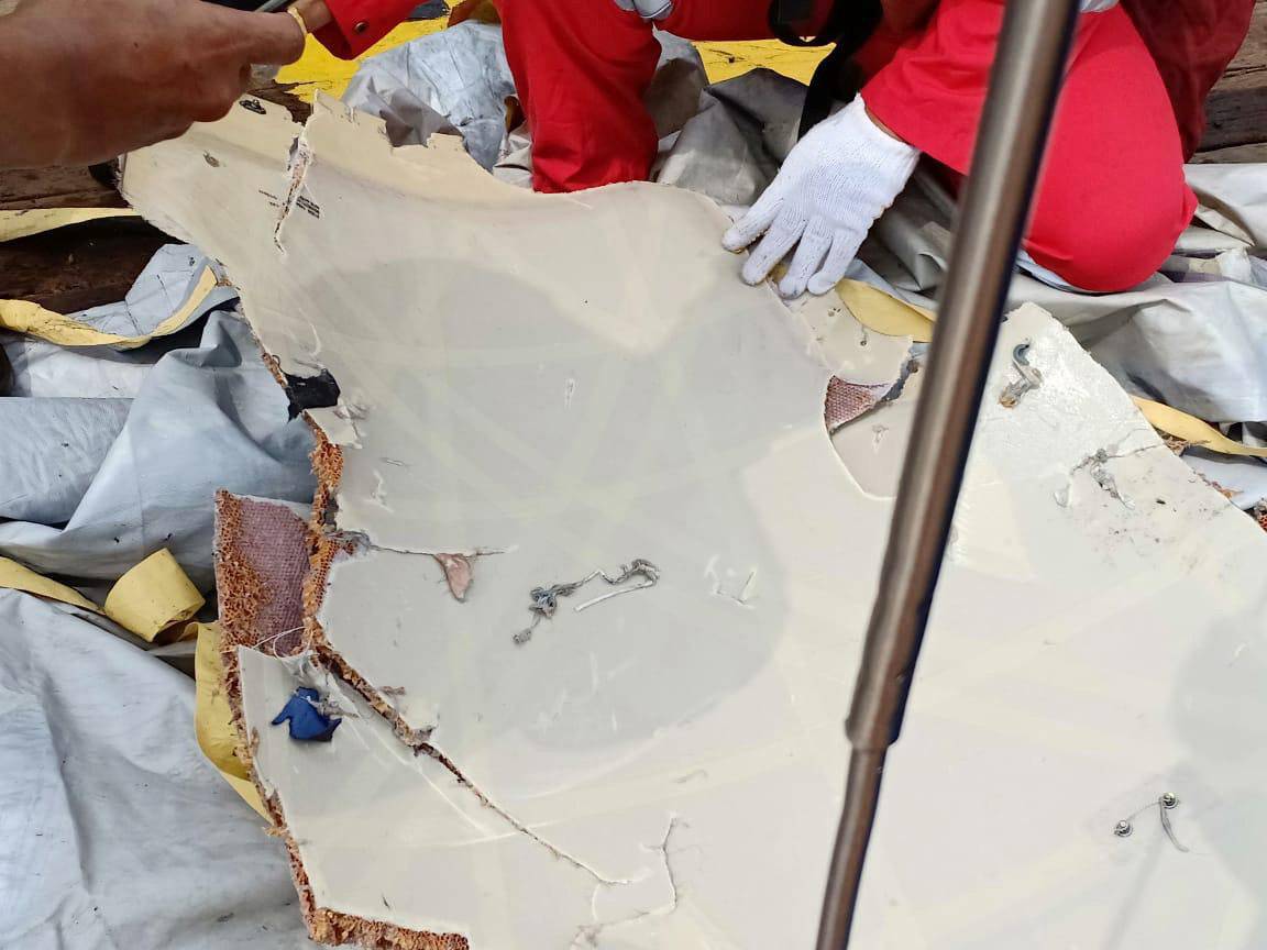 Workers of PT Pertamina examine recovered debris of what is believed from the crashed Lion Air flight JT610, onboard Prabu ship owned by PT Pertamina, off the shore of Karawang regency