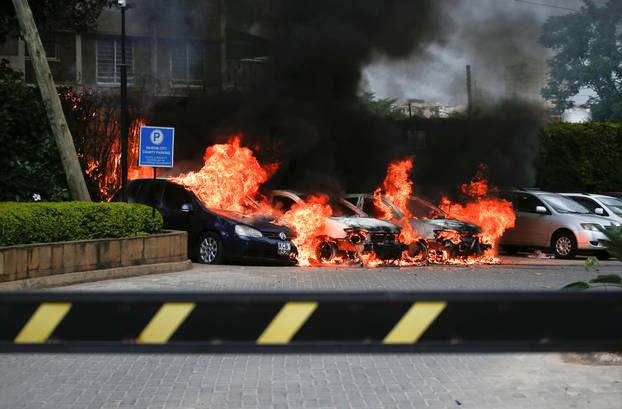 Burning cars are seen at the scene where explosions and gunshots were heard at the Dusit hotel compound, in Nairobi