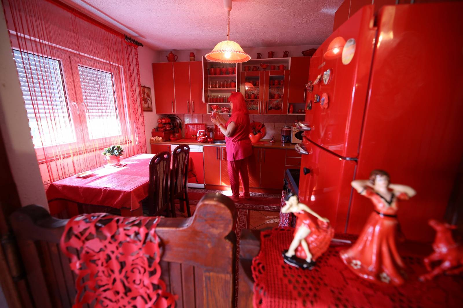 Zorica Rebernik, obsessed with the red color, stands in the kitchen inside her house in the village of Breze near Tuzla