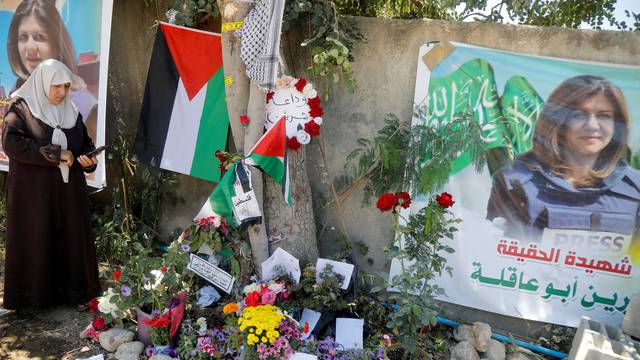 FILE PHOTO: A Palestinian woman takes pictures at the scene where Al Jazeera reporter Shireen Abu Akleh was shot dead during an Israeli raid, in Jenin
