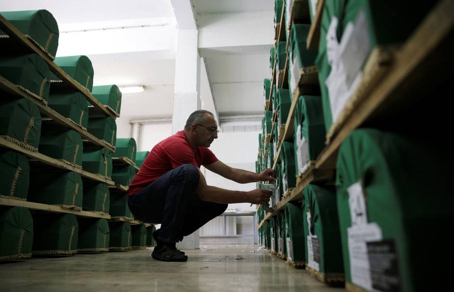 A worker prepares coffins containing the remains of victims from the 1995 Srebrenica massacre, at a morgue in the central Bosnian town of Visoko