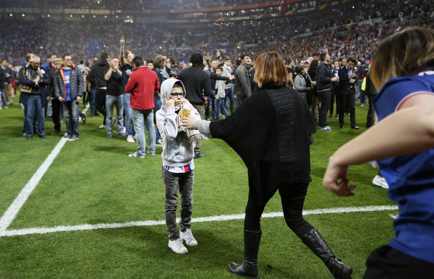 Lyon fans on the pitch as fans clash in the stands