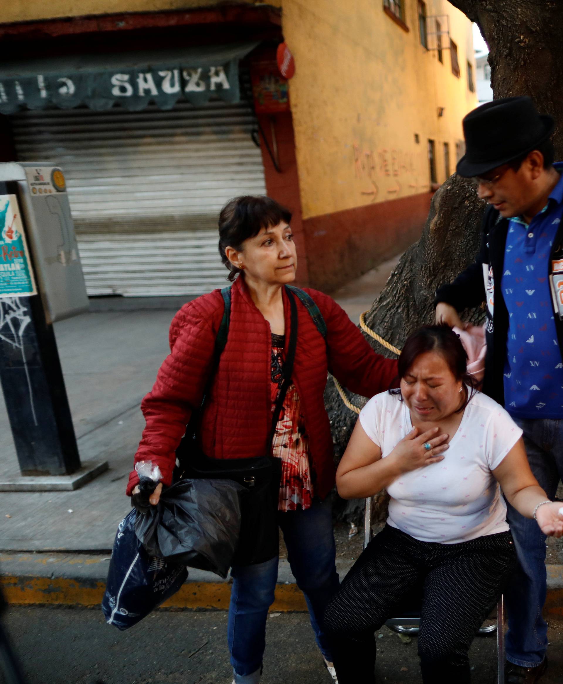 People react after an earthquake shook buildings in Mexico City