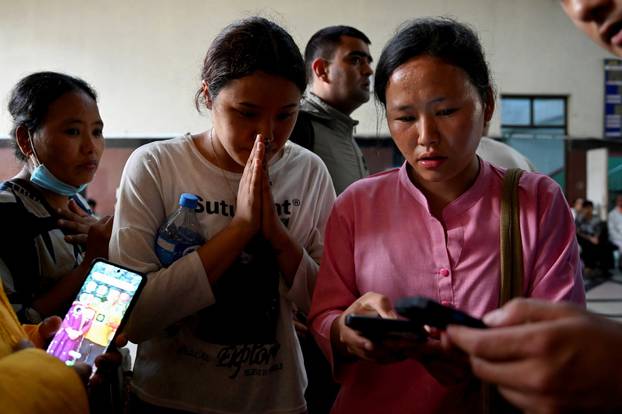 Family members check a list of people who were injured following a deadly flash flood, outside a trauma centre of Bir Hospital in Kathmandu