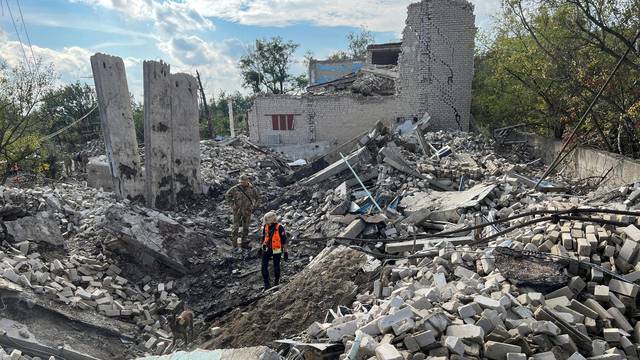 Volunteers search for bodies of people killed during Russia's attack in the town of Izium