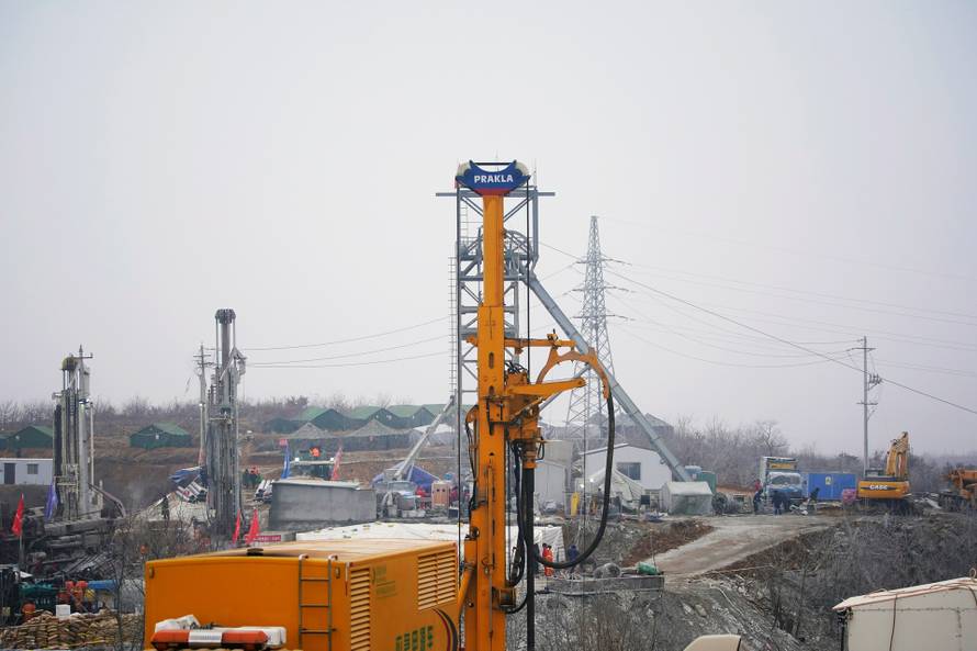 Rescuers work at the Hushan gold mine where workers were trapped underground after an explosion, in Qixia