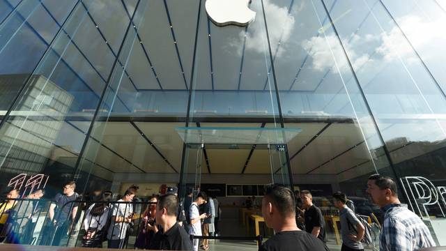 People queue outside an Apple store as the new iPhones go on sale, in Hangzhou