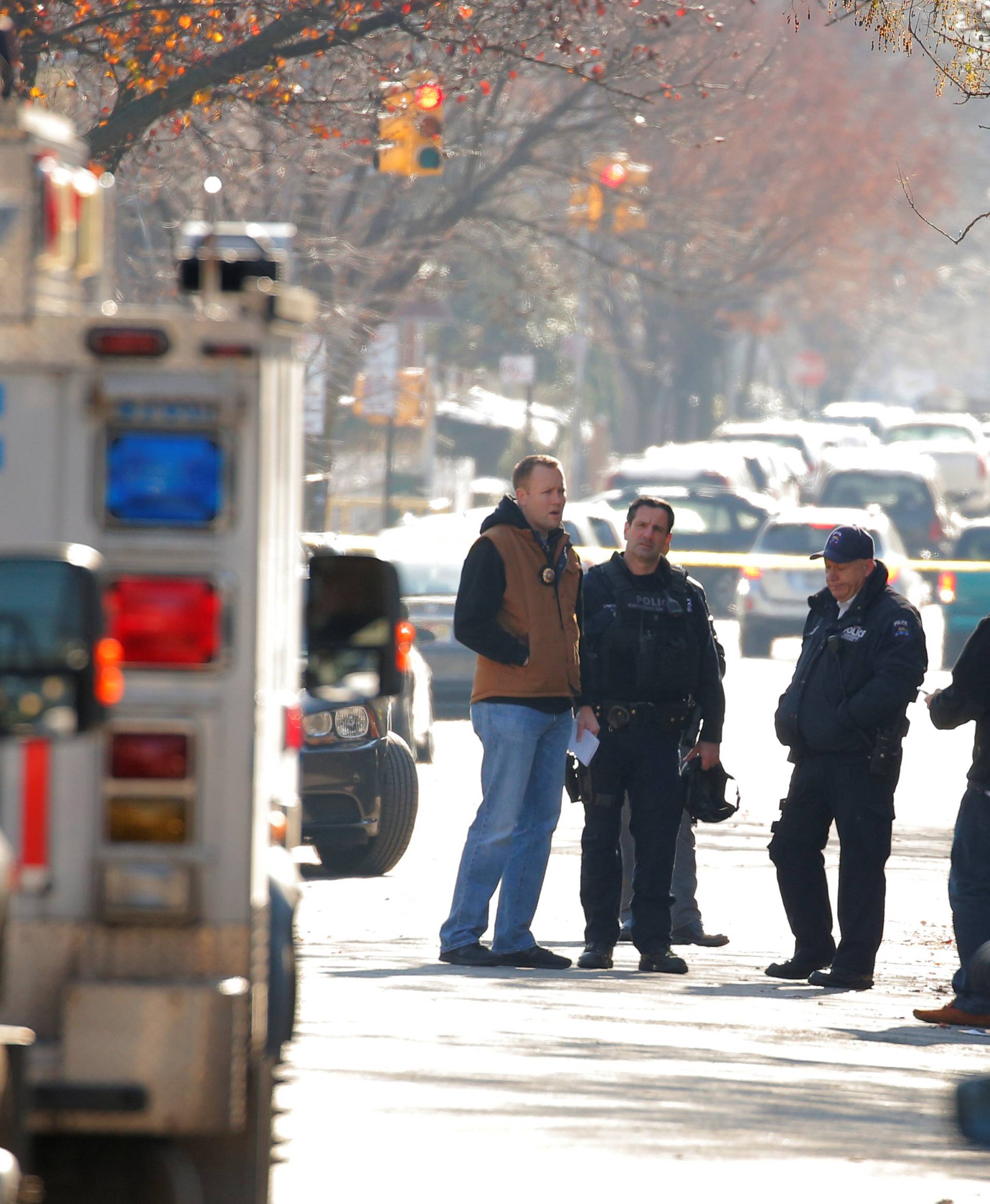 Police gather outside a house in the Brooklyn borough, while they investigate an earlier incident of the reported explosion at the New York Port Authority Bus Terminal in Manhattan, in New York City