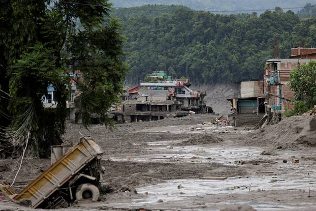 Mud covers houses and a road following a flash flood at Trishuli, Nepal