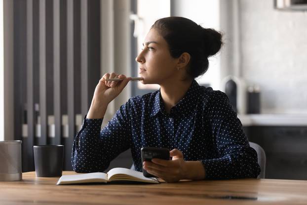 Pensive,Young,Hindu,Female,Study,By,Desk,Using,Mobile,Internet