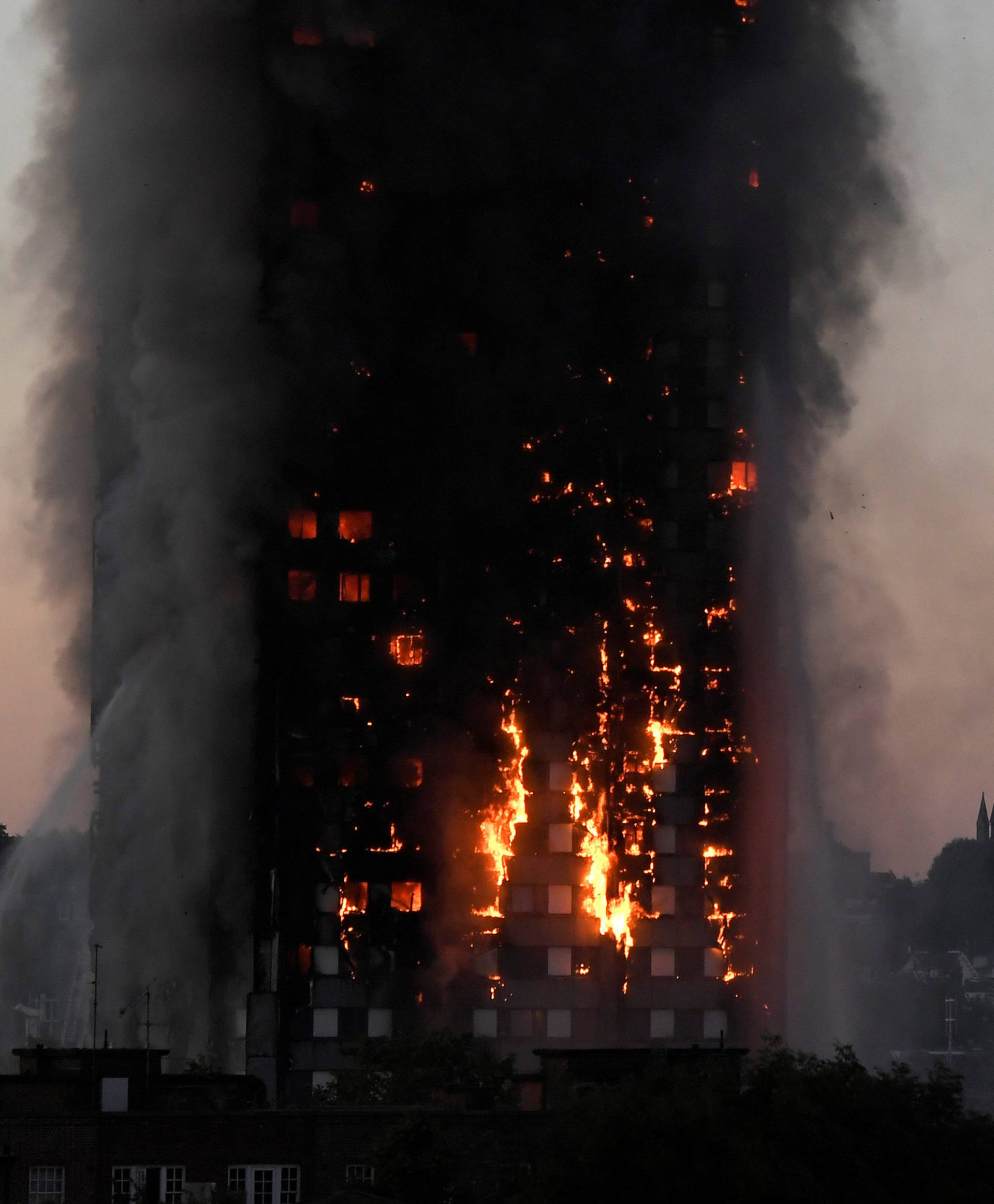 Flames and smoke billow as firefighters deal with a serious fire in the Grenfell Tower apartment block at Latimer Road in West London