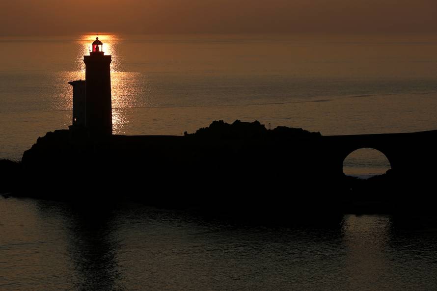 View of the Phare du Petit Minou as the sun sets over the Atlantic Ocean on a cold winter day in Plouzane