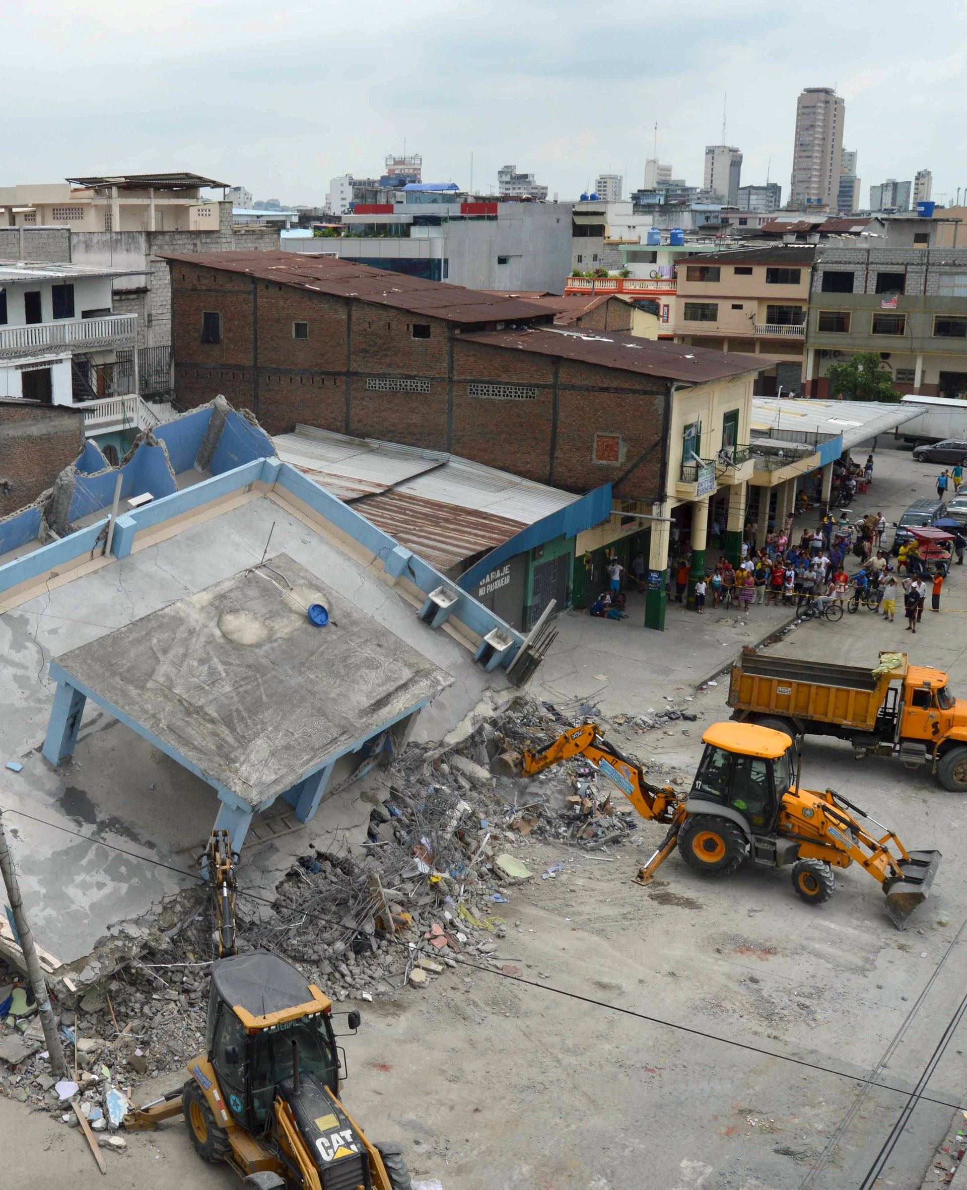 The debris of a collapsed house is cleared after an earthquake struck off the Pacific coast, in Guayaquil