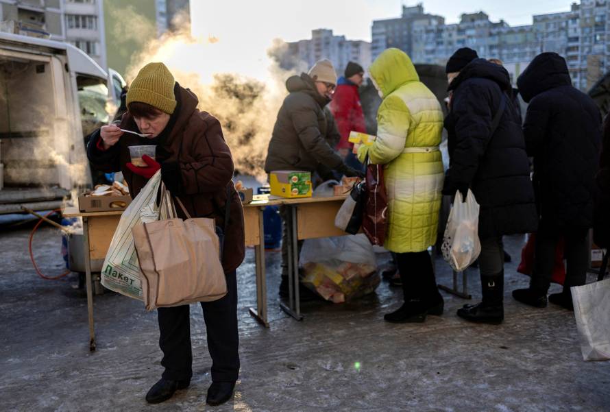 Residents receive food donations in a neighbourhood with electricity and heating outages following recent Russian attacks on Ukraine’s civilian infrastructure during subzero temperatures in Kyiv