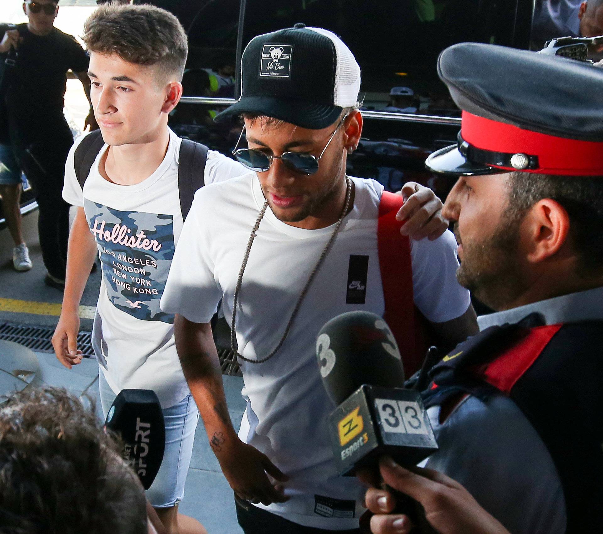 Brazilian soccer player Neymar walks in to a departure terminal at the airport in Barcelona