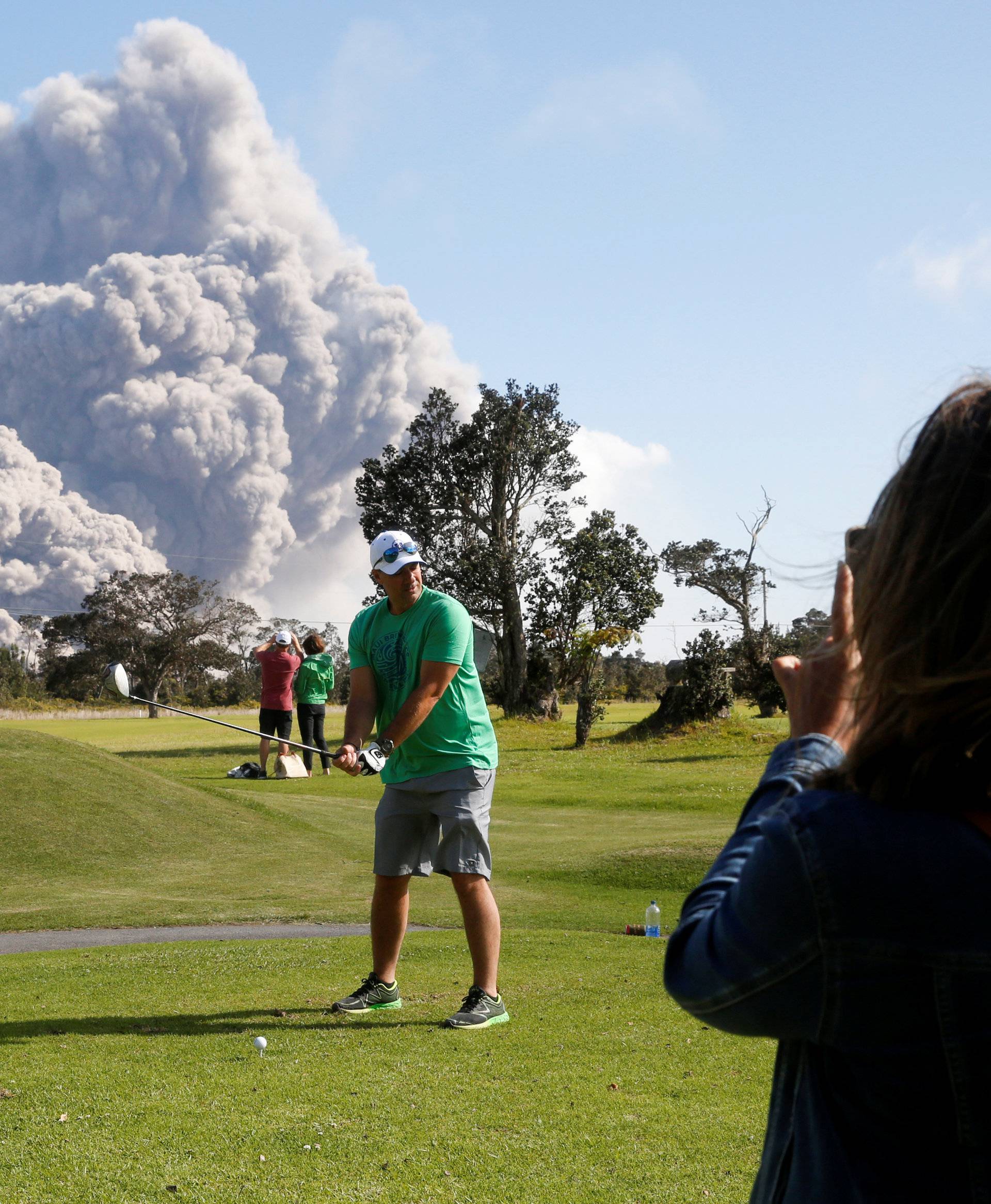 Sean Bezecny, 46, of Houston, Texas, poses for a photo as ash erupts from the Halemaumau Crater near the community of Volcano