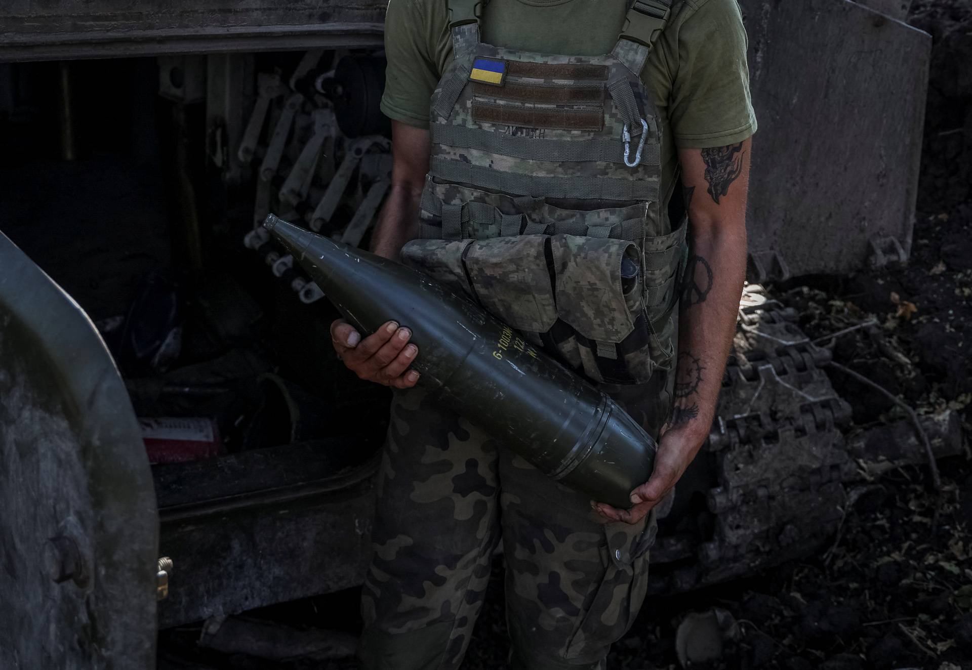 A Ukrainian servicemen stands near a self propelled howitzer before firing towards Russian troops in  the Donetsk region