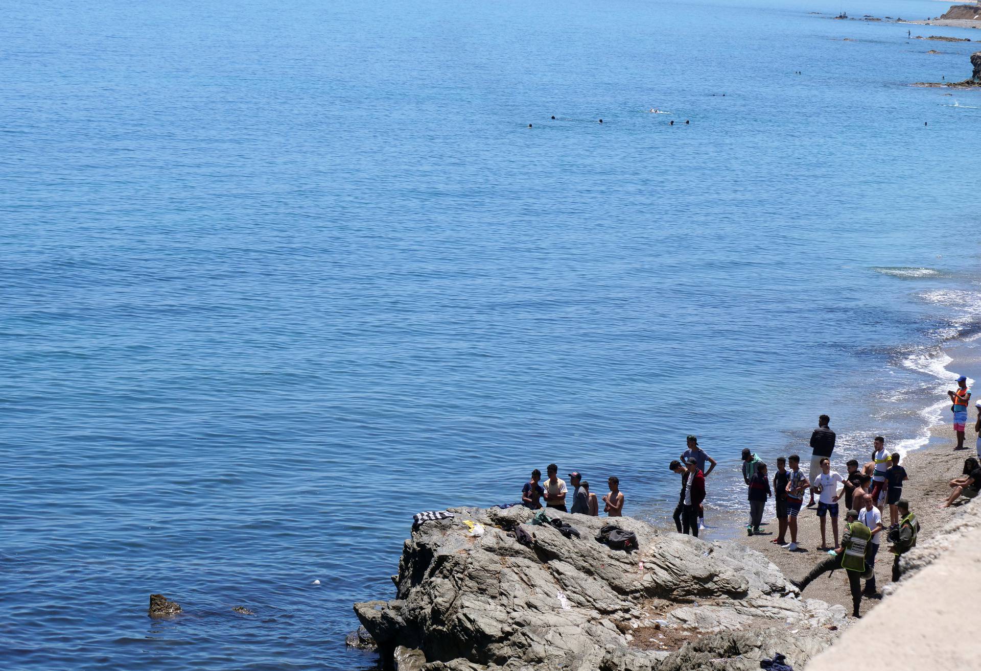 Migrants stand at the beach in Fnideq, close to the Spanish enclave Ceuta