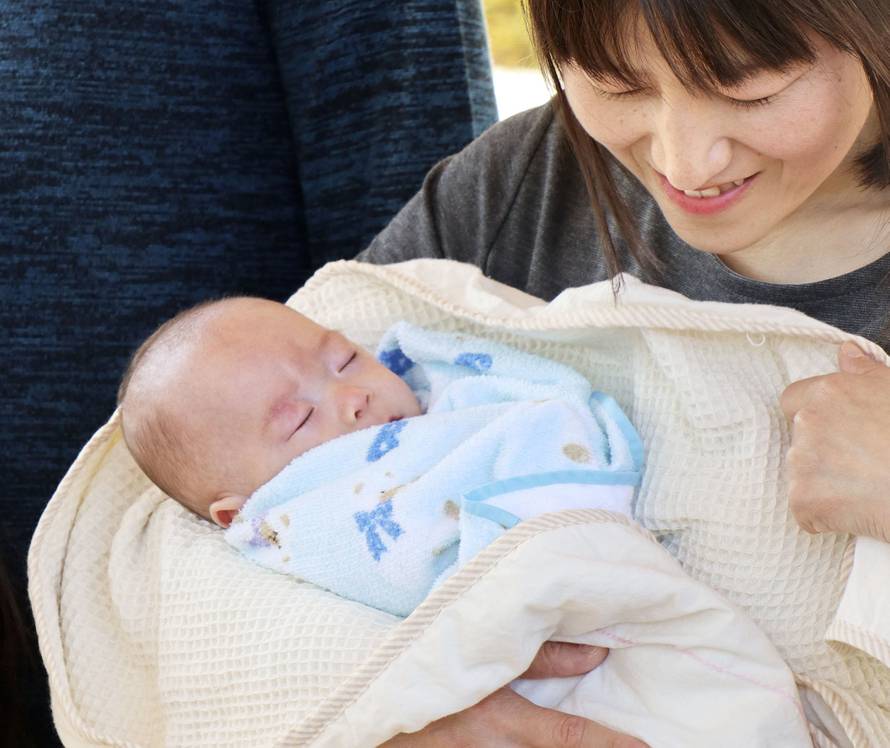 Ryusuke Sekino, a baby recognized as the world's smallest baby boy, is held in the arms of his mother Toshiko Sekino, as he is discharged from a hospital in Azumino