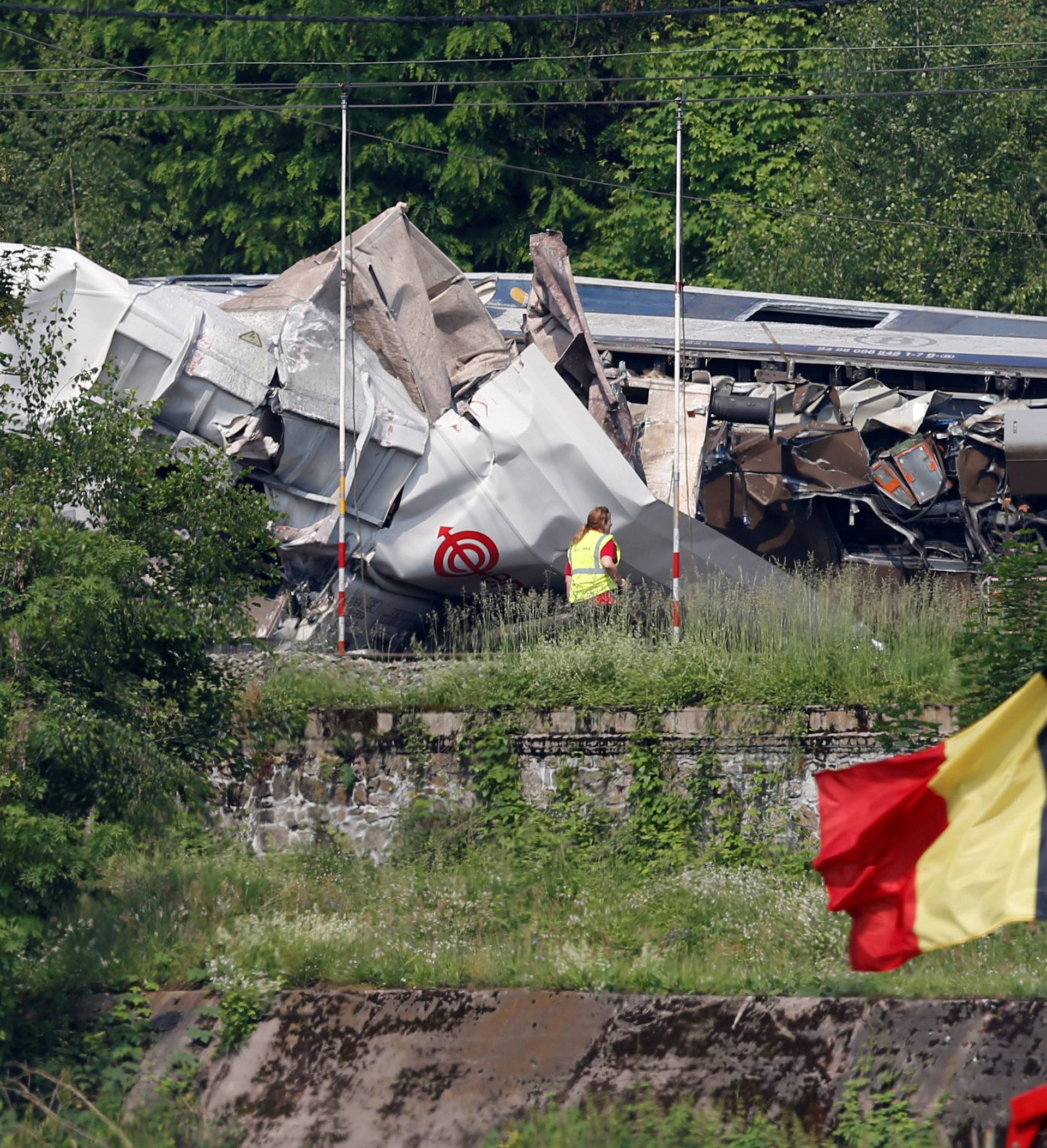 An official inspects the wreckage of a passenger train after it crashed into the back of a freight train in the eastern Belgian municipality of Saint-Georges-Sur-Meuse