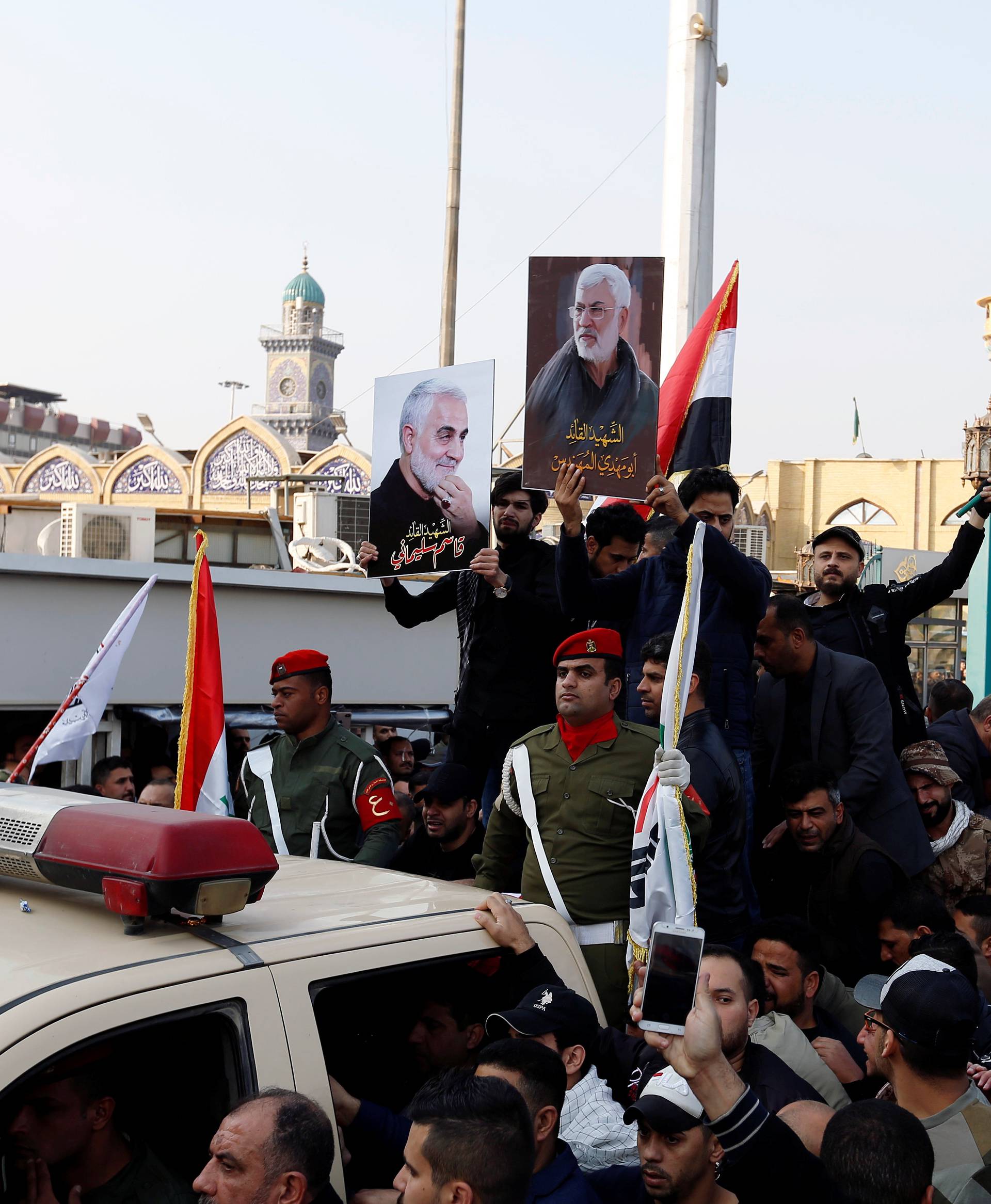 Mourners gather around the car which carries the coffins of the Iranian Major-General Qassem Soleimani and the Iraqi militia commander Abu Mahdi al-Muhandis, during their funeral in Baghdad