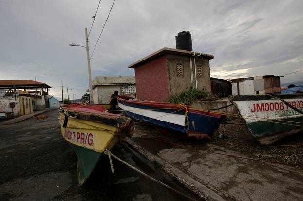 Boats are secured along a street as a resident looks on at Port Royal while Hurricane Matthew approaches in Kingston, Jamaica
