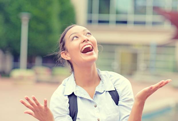 Successful happy business woman with arms up celebrating victory