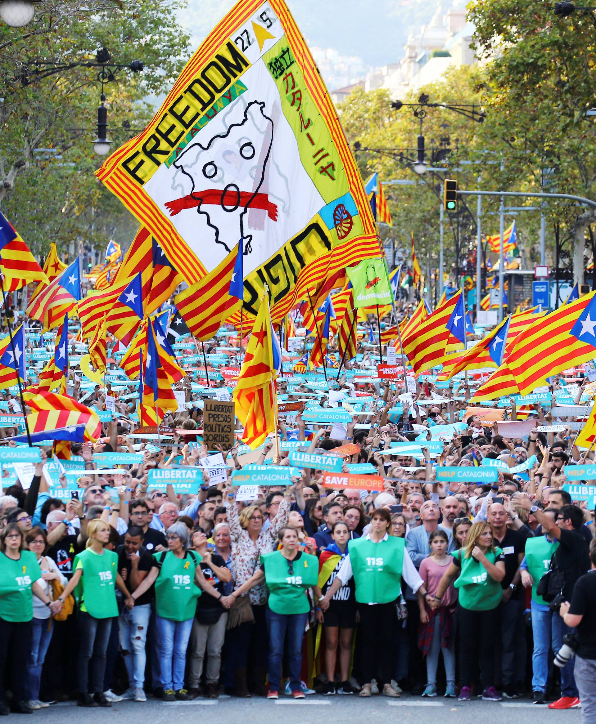 People wave separatisy Catalan flags and placards during a demonstration organised by Catalan pro-independence movements ANC (Catalan National Assembly) and Omnium Cutural, following the imprisonment of their two leaders in Barcelona